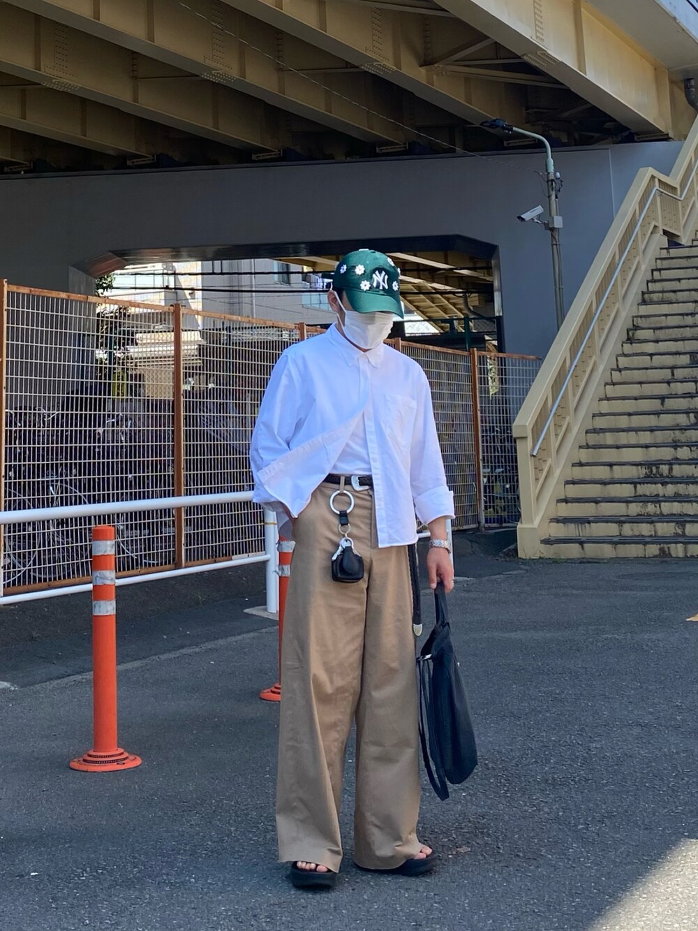 ブラック系のサンダル、ホワイト系のシャツ/ブラウス、ベージュ系のチノパンツを着用したメンズの夏コーディネートの4枚目の写真