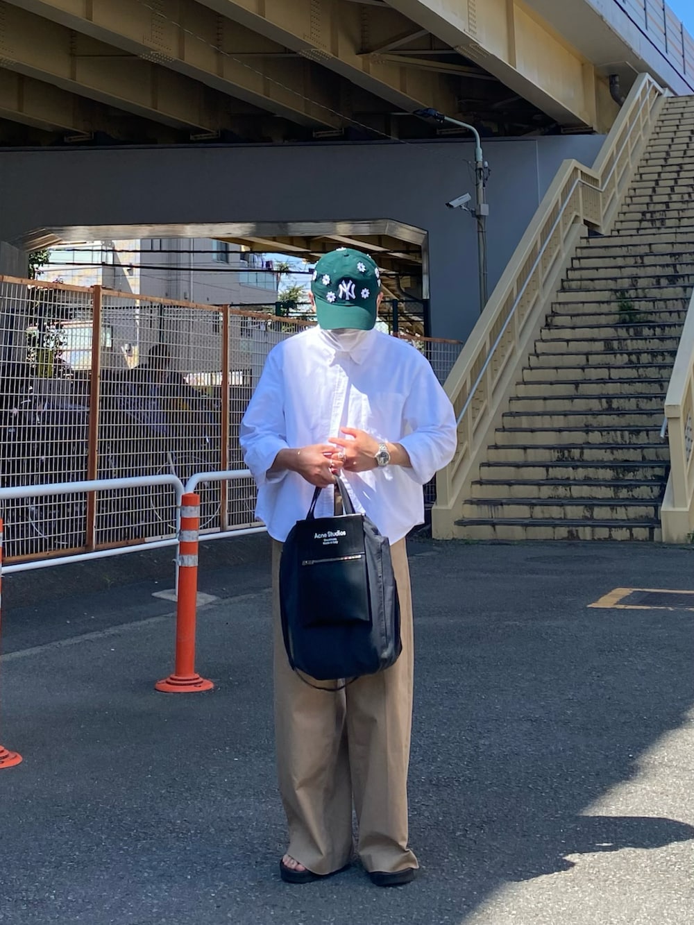 ブラック系のサンダル、ホワイト系のシャツ/ブラウス、ベージュ系のチノパンツを着用したメンズの夏コーディネートの3枚目の写真