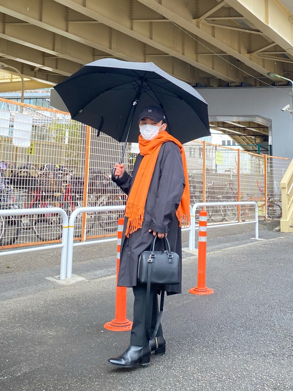 ブラック系のモッズコート、ブラウン系のカーディガン/ボレロ、ホワイト系のTシャツ/カットソーを着用したメンズの春コーディネートの2枚目の写真