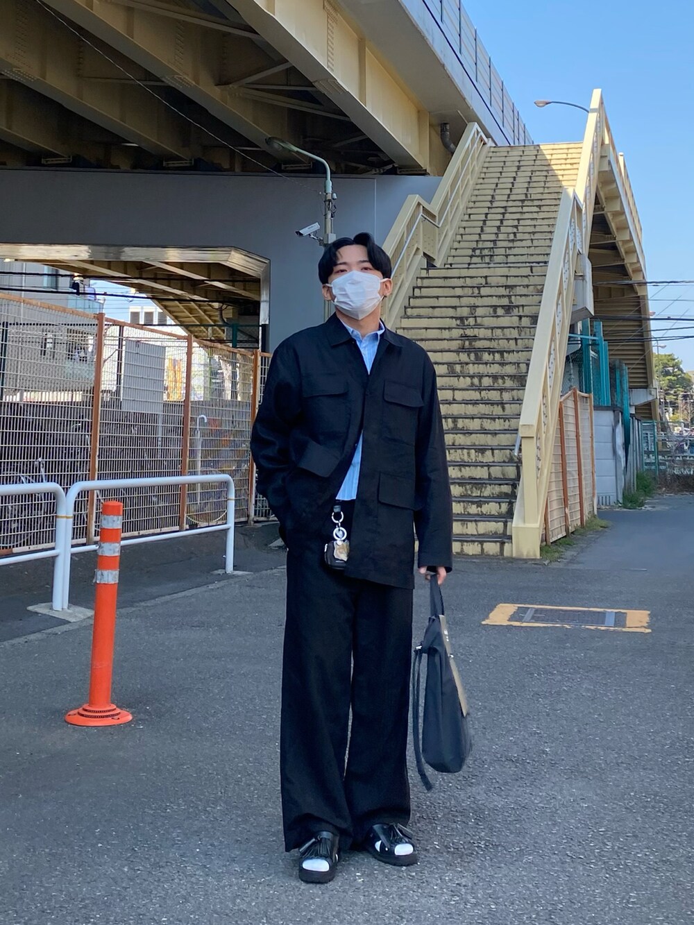 ブラック系のジャケット/アウター、ブルー系のシャツ/ブラウス、ブラック系のトートバッグを着用したメンズの春コーディネートの5枚目の写真