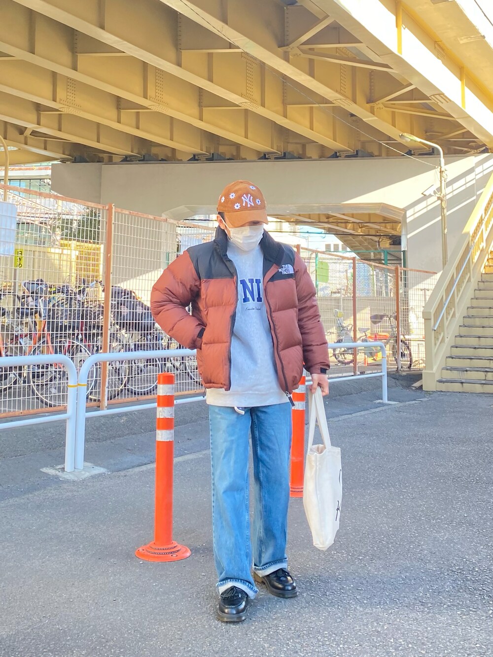 ブラウン系のダウンジャケット/コート、グレー系のスウェット、ブルー系のデニムパンツを着用したメンズの冬コーディネートの5枚目の写真