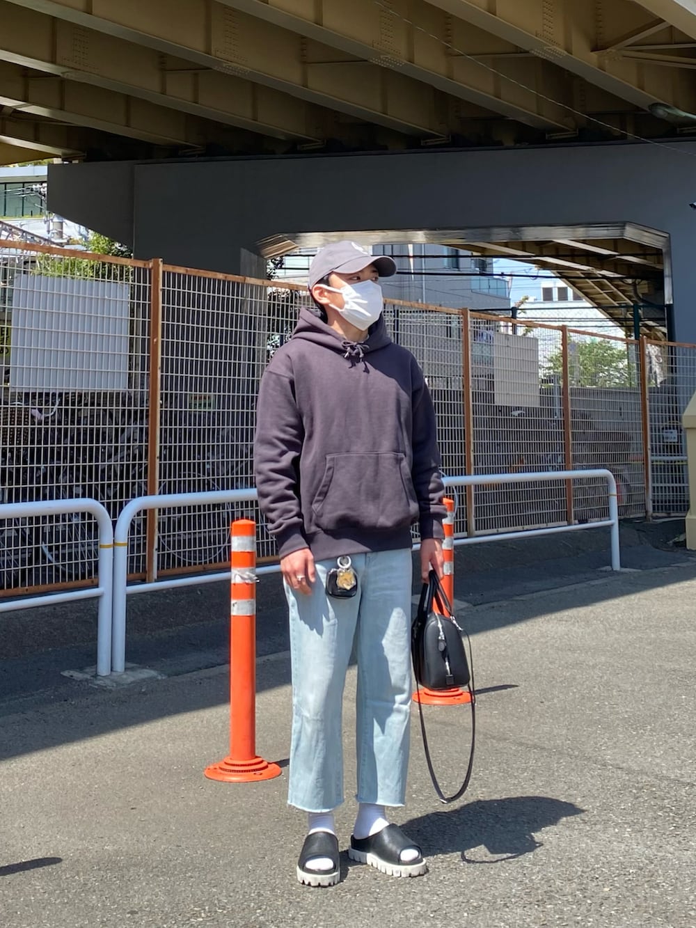 グレー系のパーカー、ブルー系のデニムパンツ、ブラック系のサンダルを着用したメンズの春コーディネートの3枚目の写真