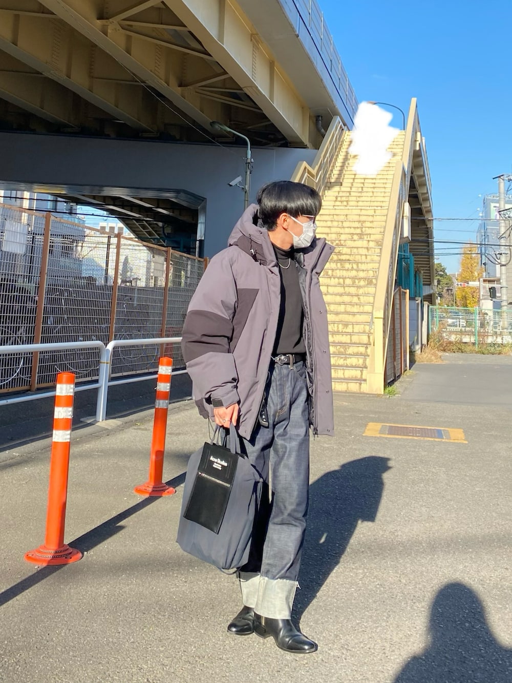 グレー系のダウンジャケット/コート、ブラック系のスウェット、ブルー系のデニムパンツを着用したメンズの冬コーディネートの4枚目の写真