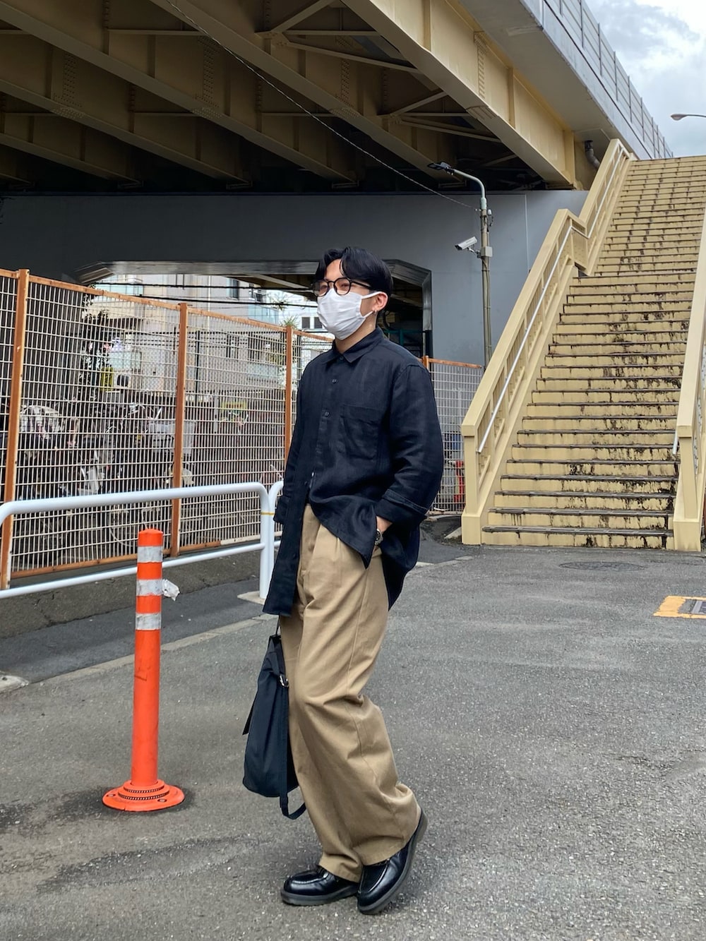 ブラック系のシャツ/ブラウス、ベージュ系のチノパンツ、ブラック系のローファーを着用したメンズの秋コーディネートの4枚目の写真