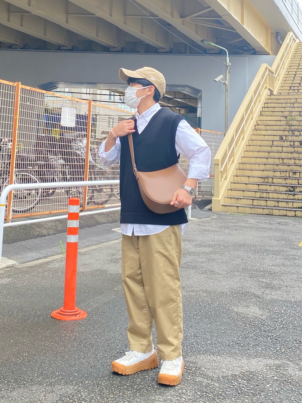 ブラック系のベスト、ホワイト系のシャツ/ブラウス、ベージュ系のチノパンツを着用したメンズの秋コーディネートの3枚目の写真