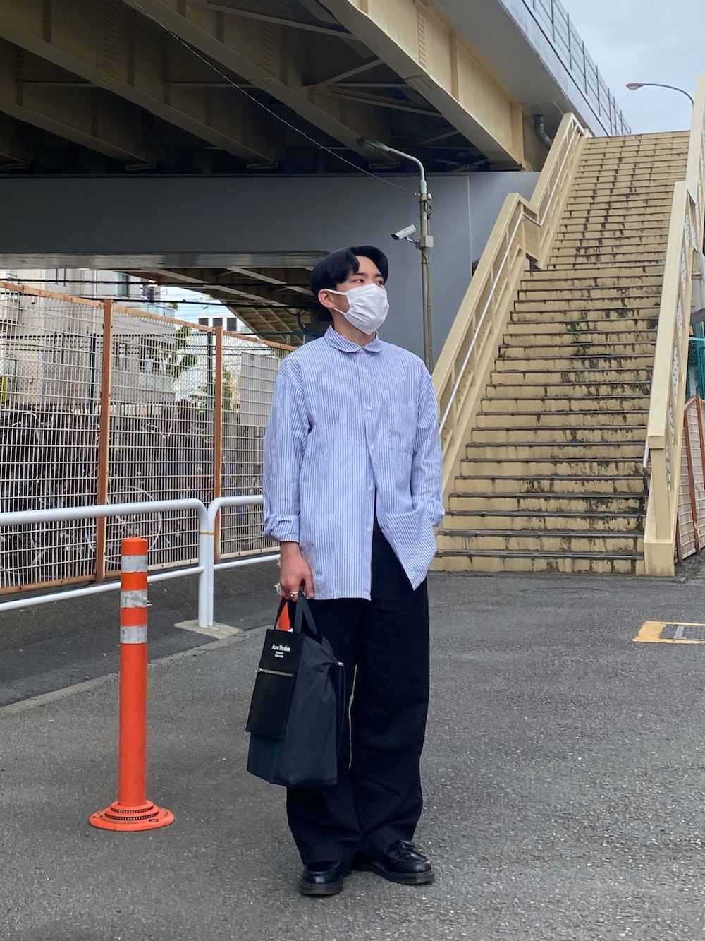 ブルー系のシャツ/ブラウス、ブラック系のトートバッグ、ブラック系のパンツを着用したメンズの春コーディネートの4枚目の写真