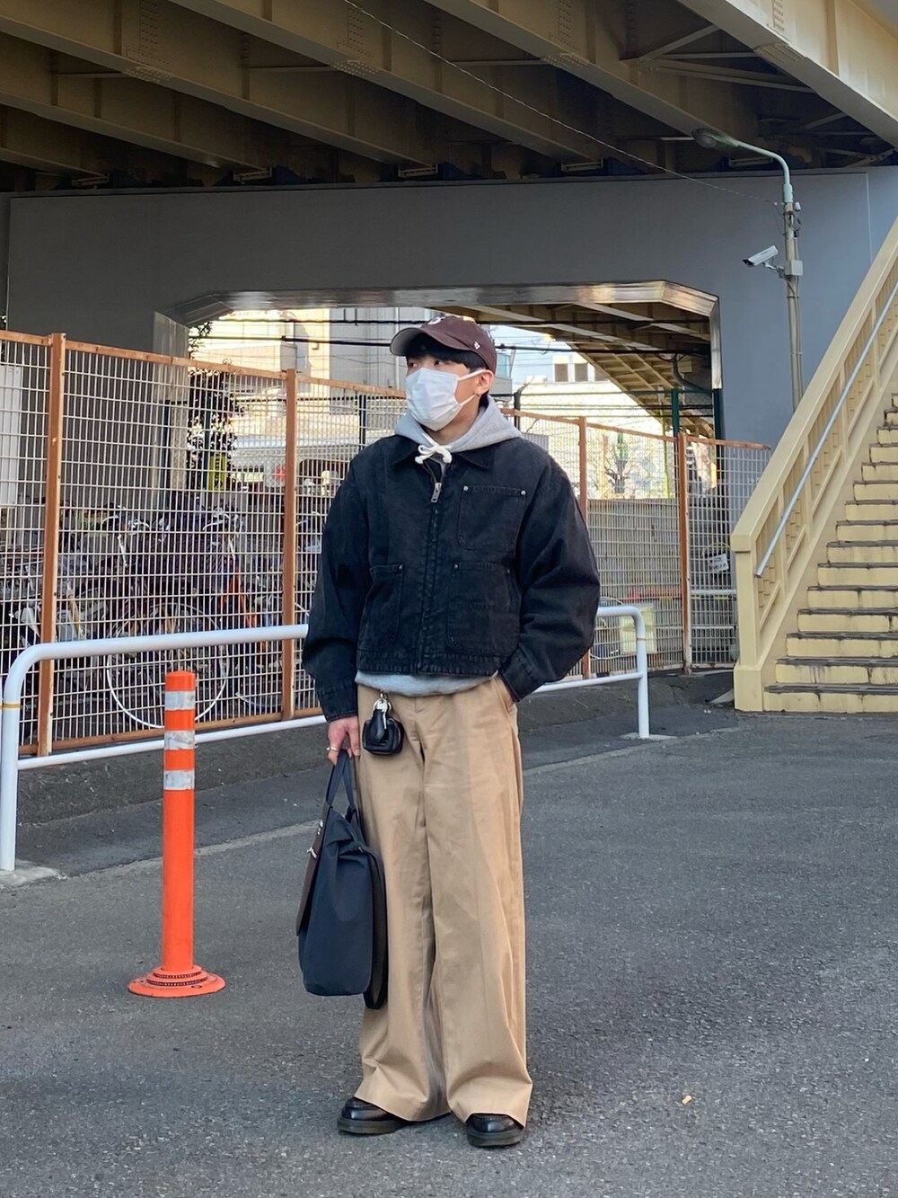 ブラック系のブルゾン、グレー系のパーカー、ベージュ系のチノパンツを着用したメンズの春コーディネートの5枚目の写真