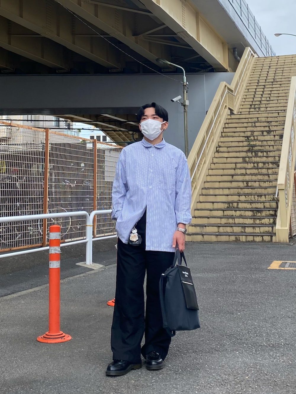 ブルー系のシャツ/ブラウス、ブラック系のトートバッグ、ブラック系のパンツを着用したメンズの春コーディネートの3枚目の写真