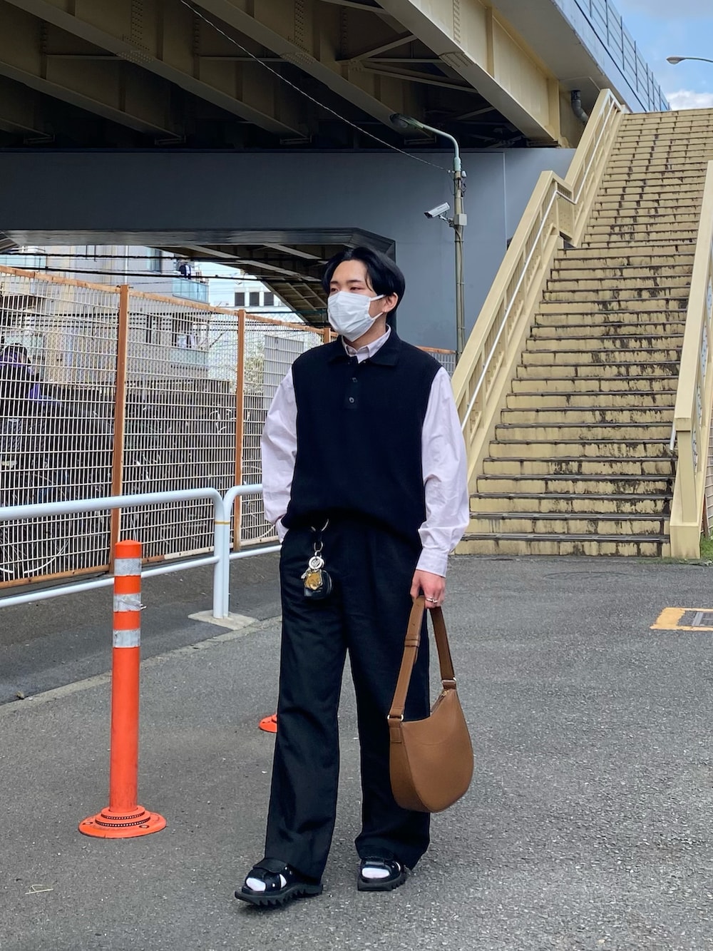 ブラック系のベスト、ピンク系のシャツ/ブラウス、ブラウン系のバッグを着用したメンズの春コーディネートの2枚目の写真