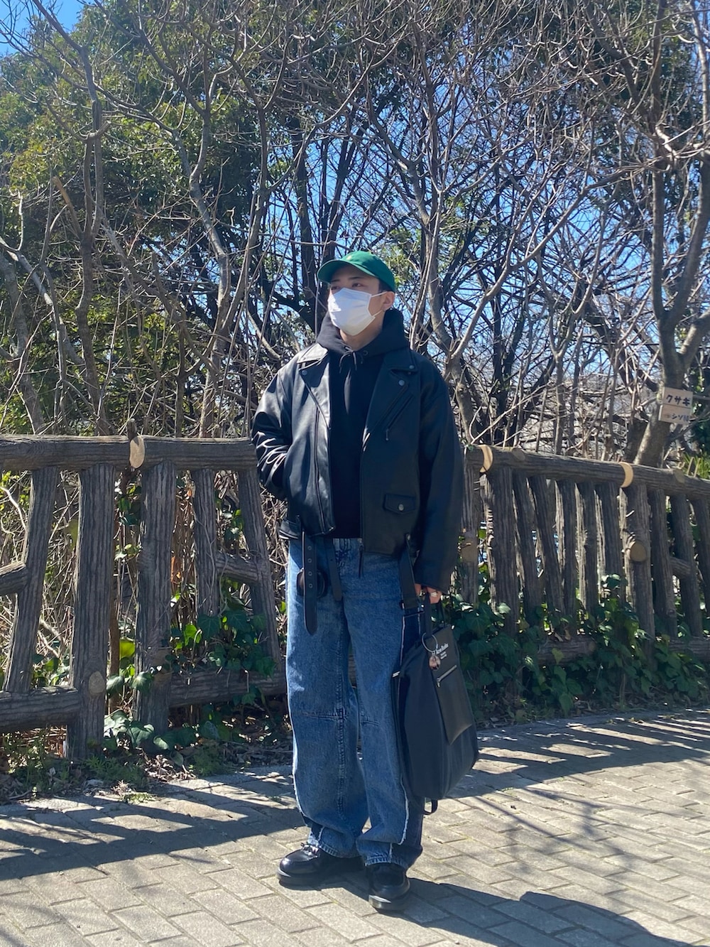 ブラック系のライダースジャケット、ブラック系のパーカー、ブルー系のデニムパンツを着用したメンズの春コーディネートの4枚目の写真