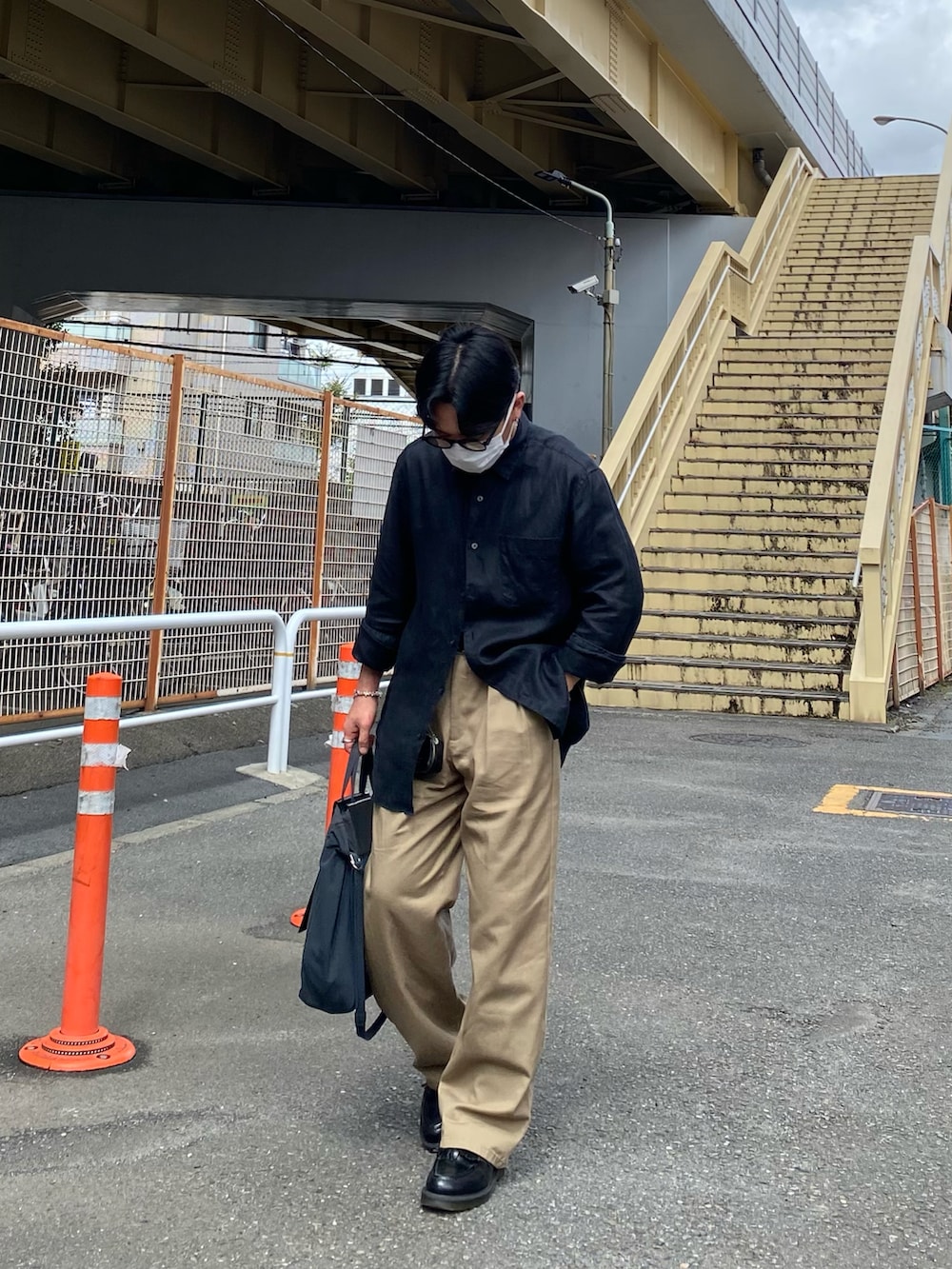 ブラック系のシャツ/ブラウス、ベージュ系のチノパンツ、ブラック系のローファーを着用したメンズの秋コーディネートの3枚目の写真