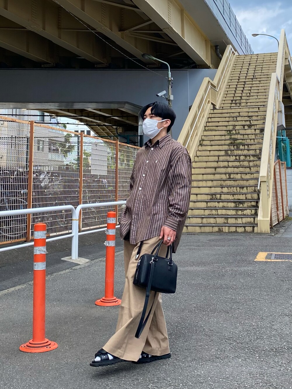 ブラウン系のシャツ/ブラウス、ベージュ系のチノパンツ、ブラック系のボストンバッグを着用したメンズの夏コーディネートの4枚目の写真