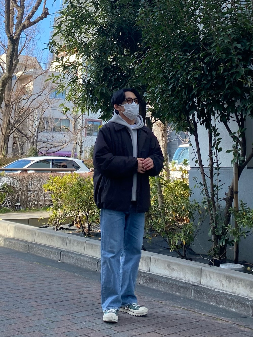 ブラック系のダウンジャケット/コート、グレー系のパーカー、ブルー系のデニムパンツを着用したメンズの冬コーディネートの2枚目の写真