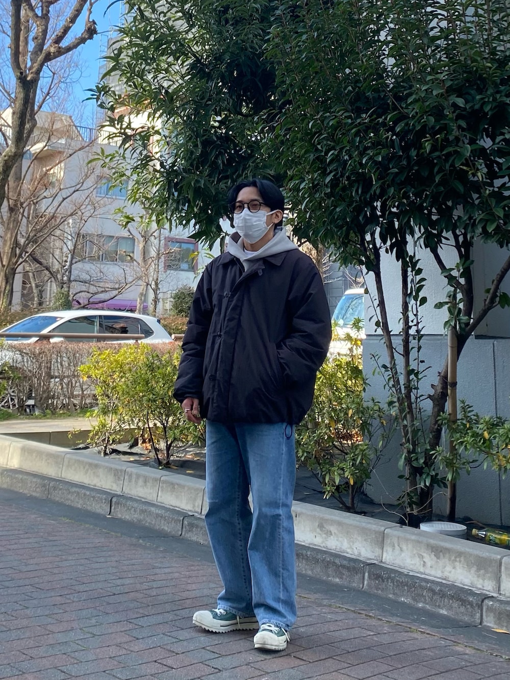 ブラック系のダウンジャケット/コート、グレー系のパーカー、ブルー系のデニムパンツを着用したメンズの冬コーディネートの3枚目の写真