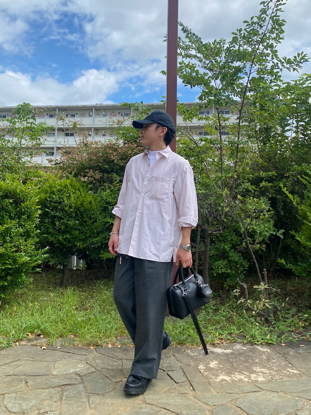 ピンク系のシャツ/ブラウス、ブラック系のボストンバッグ、グレー系のパンツを着用したメンズの夏コーディネートの4枚目の写真
