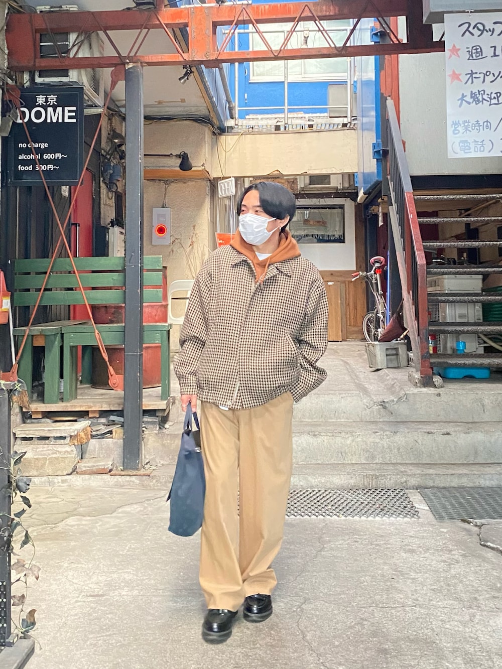 ベージュ系のブルゾン、ブラウン系のパーカー、ベージュ系のスラックスを着用したメンズの冬コーディネートの2枚目の写真