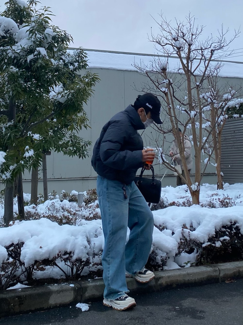 ブルー系のデニムパンツ、ブラック系のスニーカー、パープル系のTシャツ/カットソーを着用したメンズの冬コーディネートの2枚目の写真