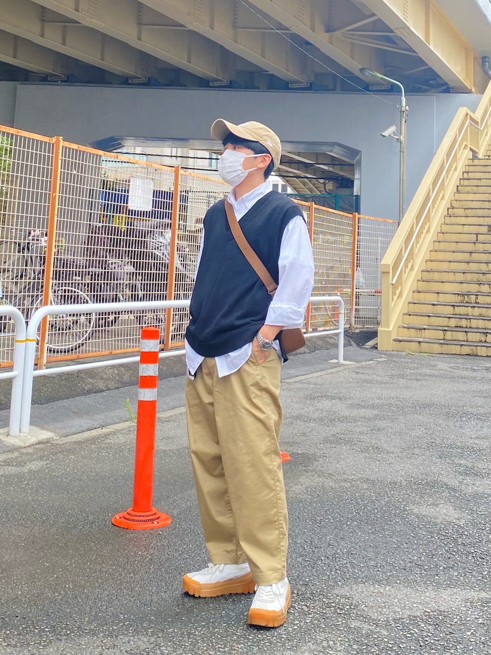 ブラック系のベスト、ホワイト系のシャツ/ブラウス、ベージュ系のチノパンツを着用したメンズの秋コーディネートの4枚目の写真