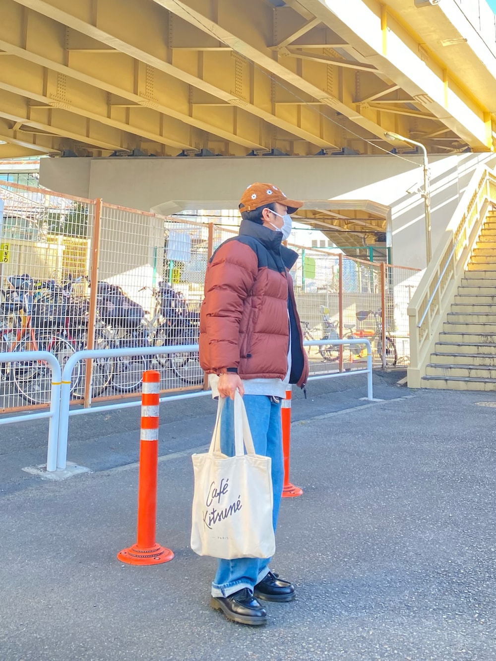 ブラウン系のダウンジャケット/コート、グレー系のスウェット、ブルー系のデニムパンツを着用したメンズの冬コーディネートの3枚目の写真