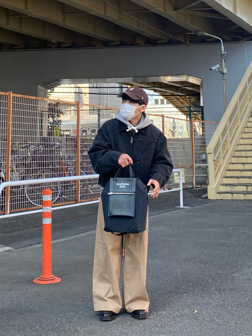 ブラック系のブルゾン、グレー系のパーカー、ベージュ系のチノパンツを着用したメンズの春コーディネートの4枚目の写真