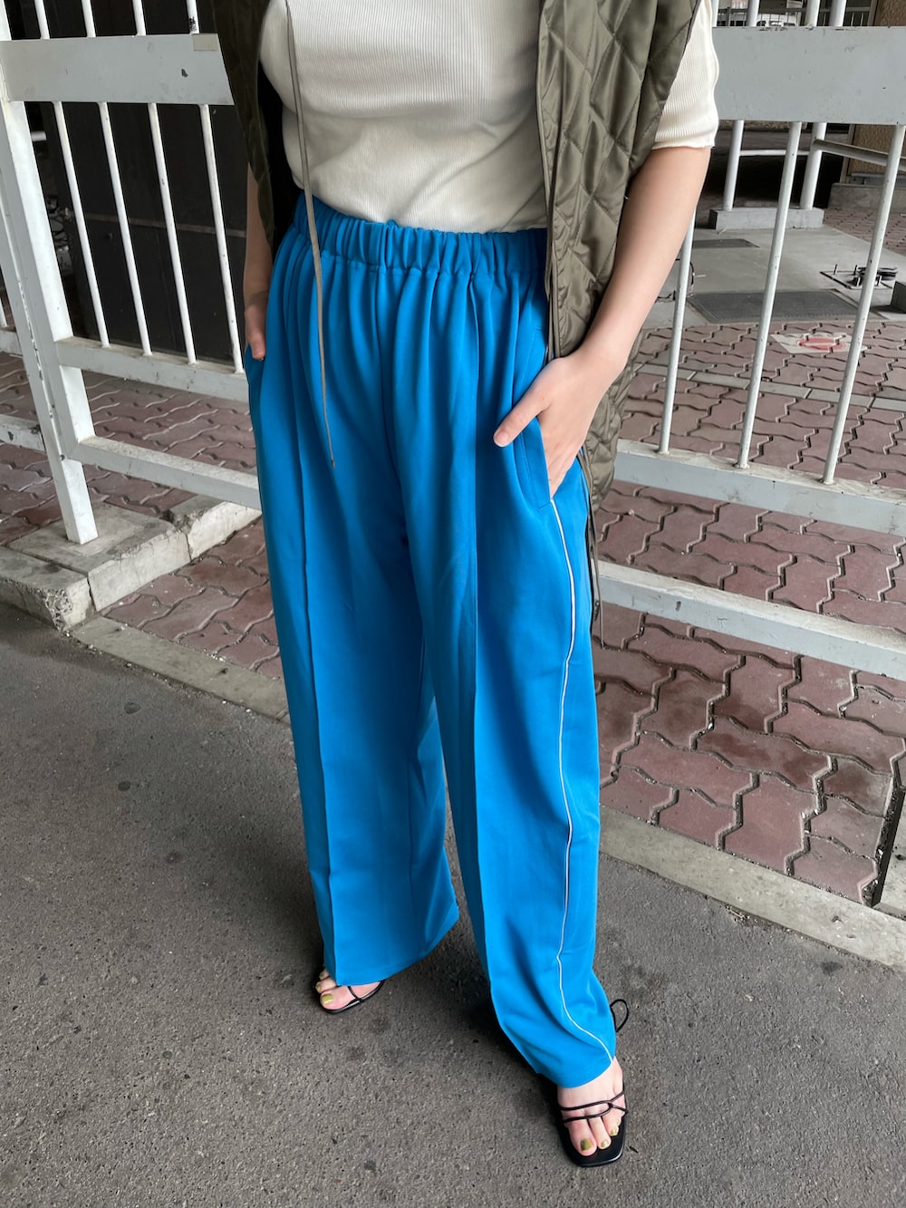 グリーン系のベスト、ブルー系のその他パンツを着用したレディースの夏コーディネートの2枚目の写真