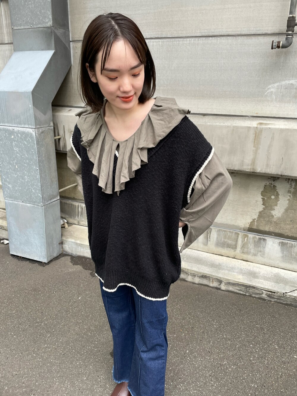 グリーン系のTシャツ/カットソー、ブラック系のベスト、ブラック系のボストンバッグを着用したレディースの冬コーディネートの2枚目の写真