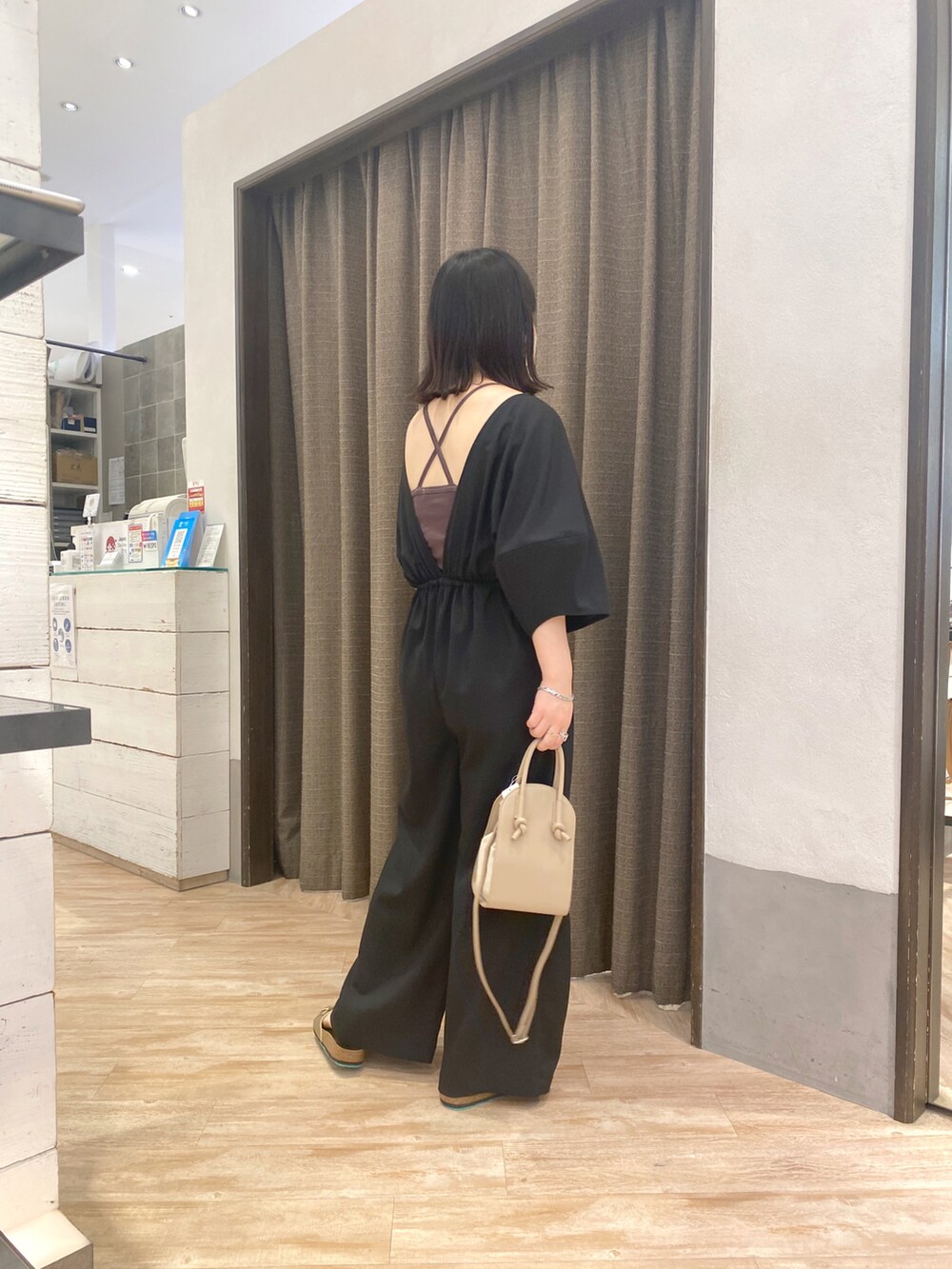 ブラック系のつなぎ/オールインワン、ベージュ系のショルダーバッグ、ゴールド系のその他シューズを着用したレディースの春コーディネートの2枚目の写真