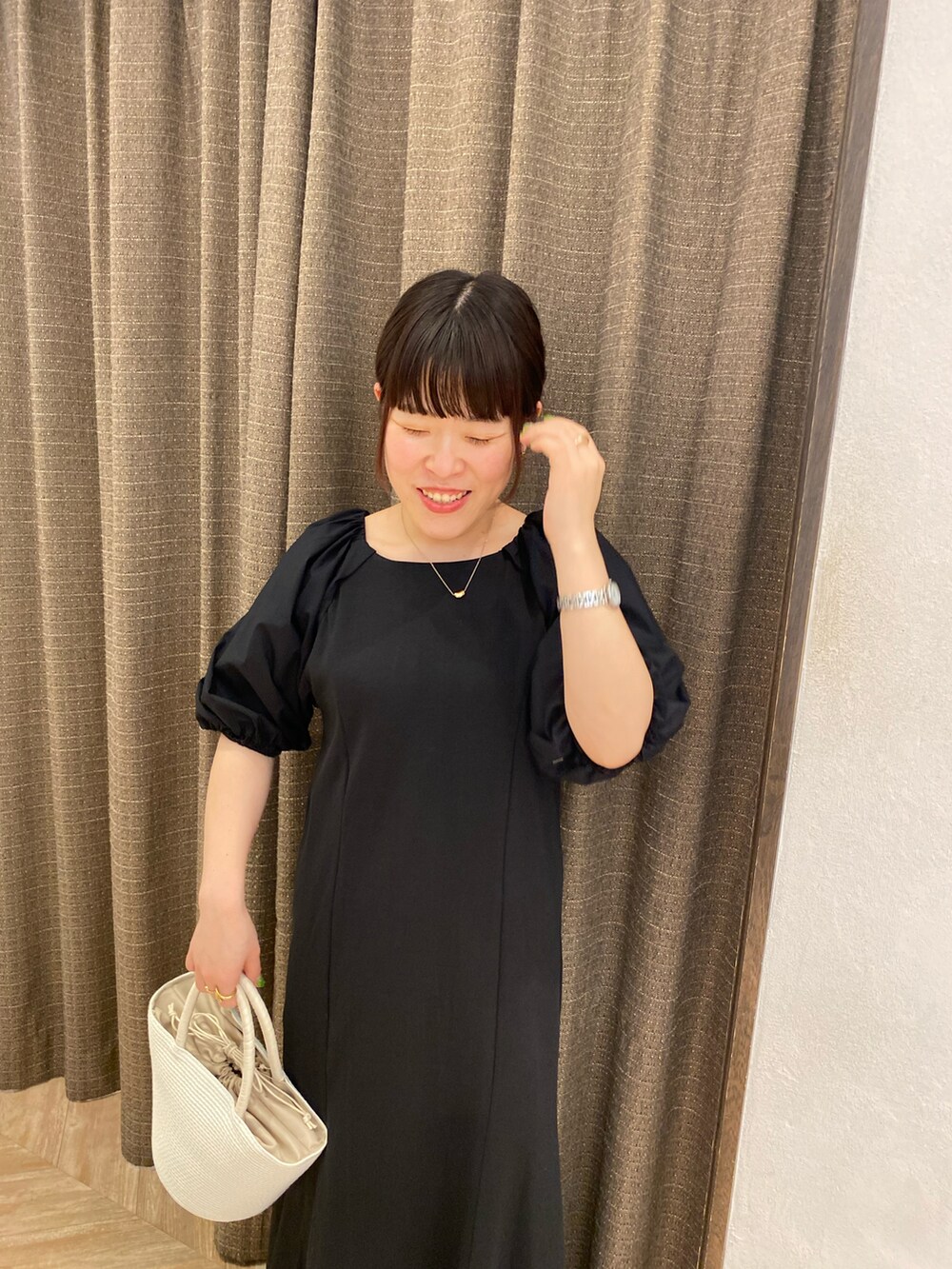 ホワイト系のハンドバッグ、ブラック系のワンピース、ブラック系のその他シューズを着用したレディースの春コーディネートの4枚目の写真