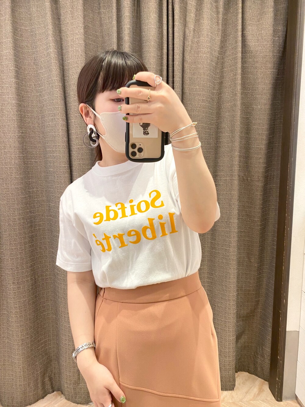 ホワイト系のスカート、オレンジ系のTシャツ/カットソーを着用したレディースの春コーディネートの2枚目の写真