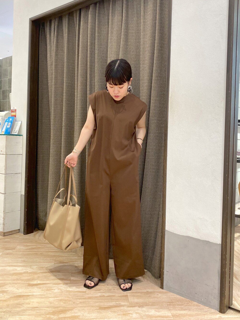 ベージュ系のトートバッグ、ブラウン系のつなぎ/オールインワンを着用したレディースの春コーディネートの2枚目の写真