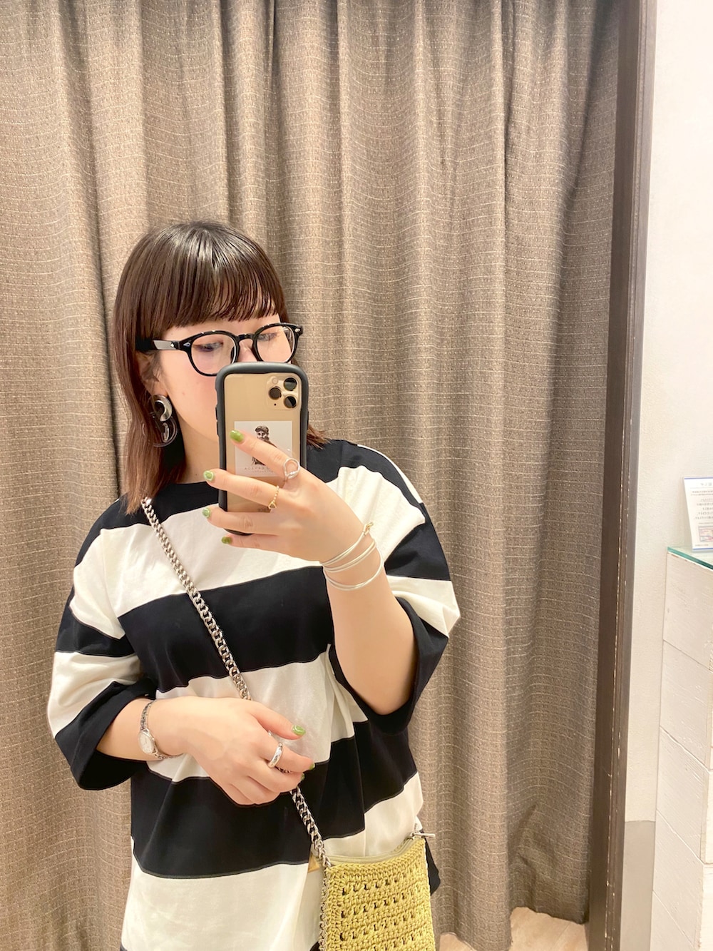 ホワイト系のTシャツ/カットソー、グリーン系のショルダーバッグ、ホワイト系のスカートを着用したレディースの春コーディネートの2枚目の写真