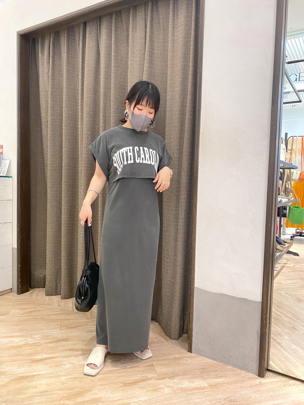 ブラック系のワンピース、ブラック系のショルダーバッグ、ホワイト系のサンダルを着用したレディースの夏コーディネートの3枚目の写真