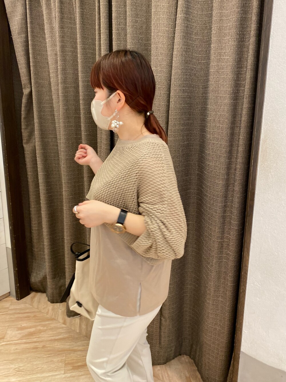 グレー系のその他パンツ、ホワイト系のトートバッグ、ベージュ系のニット/セーターを着用したレディースの春コーディネートの2枚目の写真