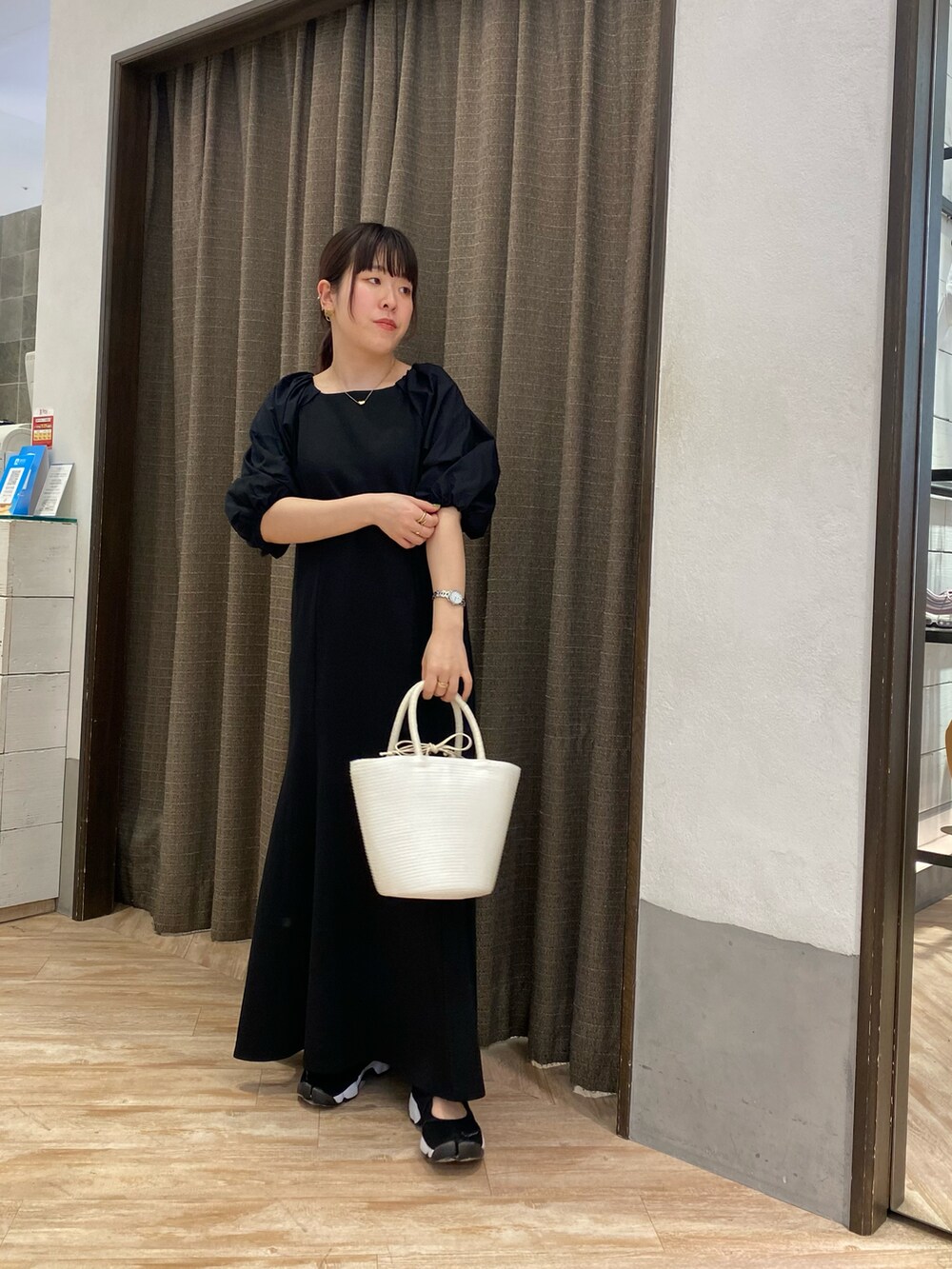 ホワイト系のハンドバッグ、ブラック系のワンピース、ブラック系のその他シューズを着用したレディースの春コーディネートの2枚目の写真