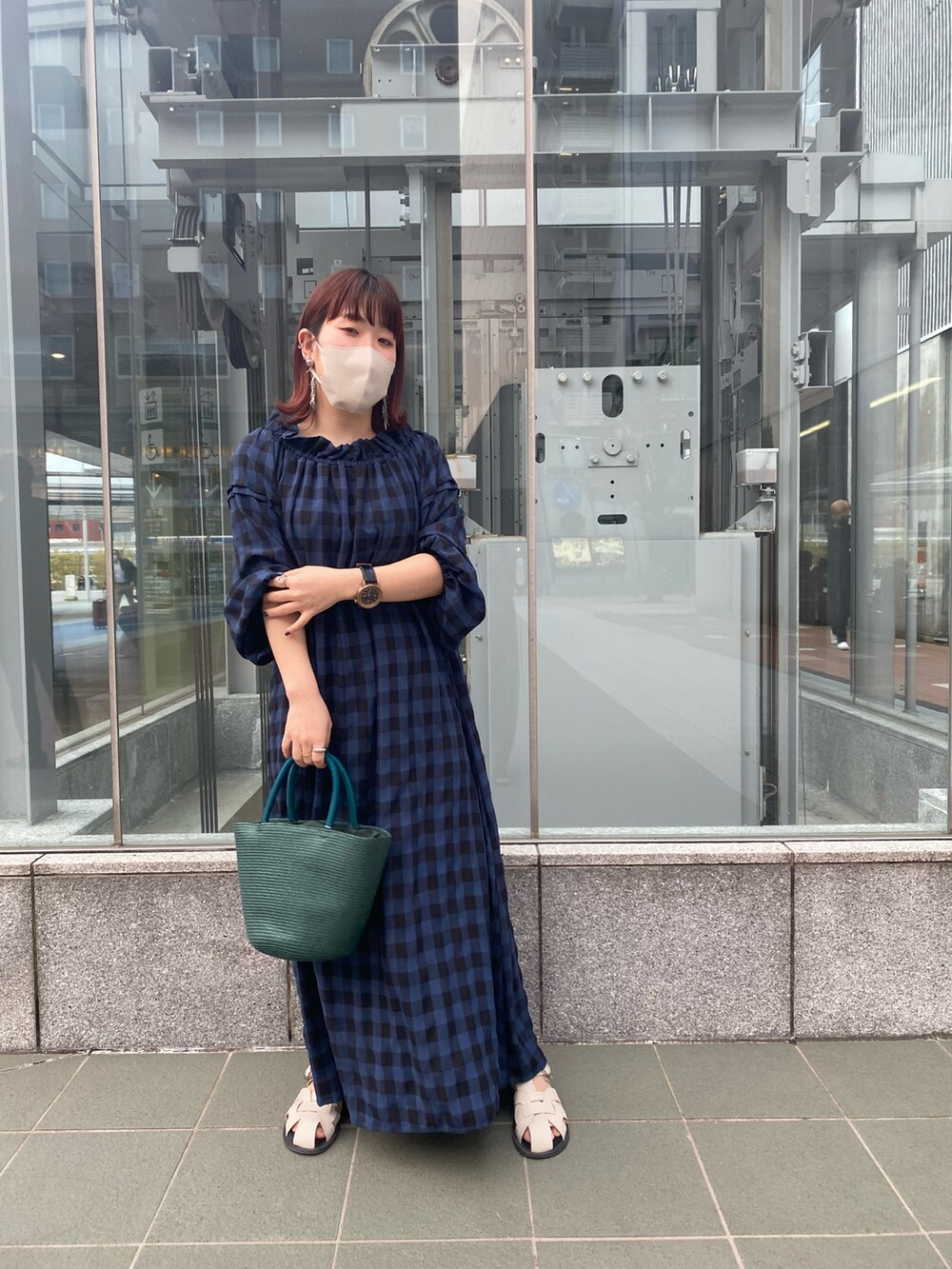 ブルー系のワンピース、グリーン系のハンドバッグ、ホワイト系のサンダルを着用したレディースの春コーディネートの3枚目の写真