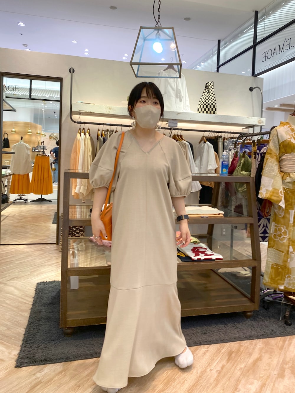 ベージュ系のワンピース、ベージュ系のショルダーバッグを着用したレディースの夏コーディネートの2枚目の写真