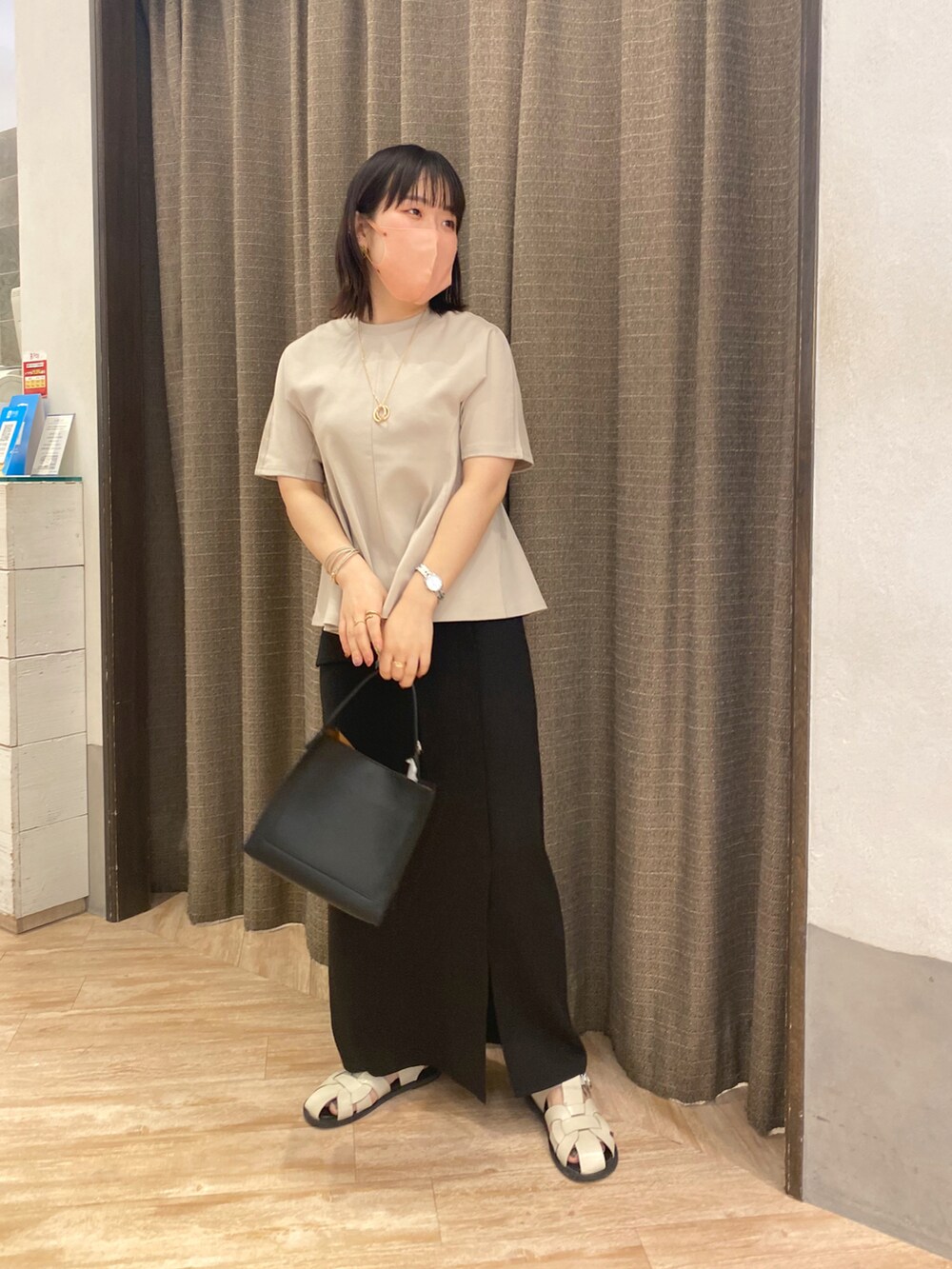 ブラック系のトートバッグ、ベージュ系のTシャツ/カットソー、ブラック系のスカートを着用したレディースの夏コーディネートの2枚目の写真