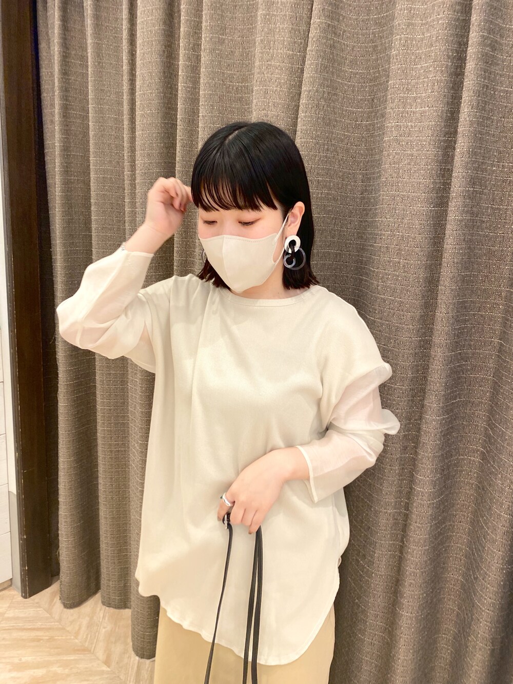 ベージュ系のTシャツ/カットソー、ベージュ系のスカート、ホワイト系のサンダルを着用したレディースの春コーディネートの3枚目の写真