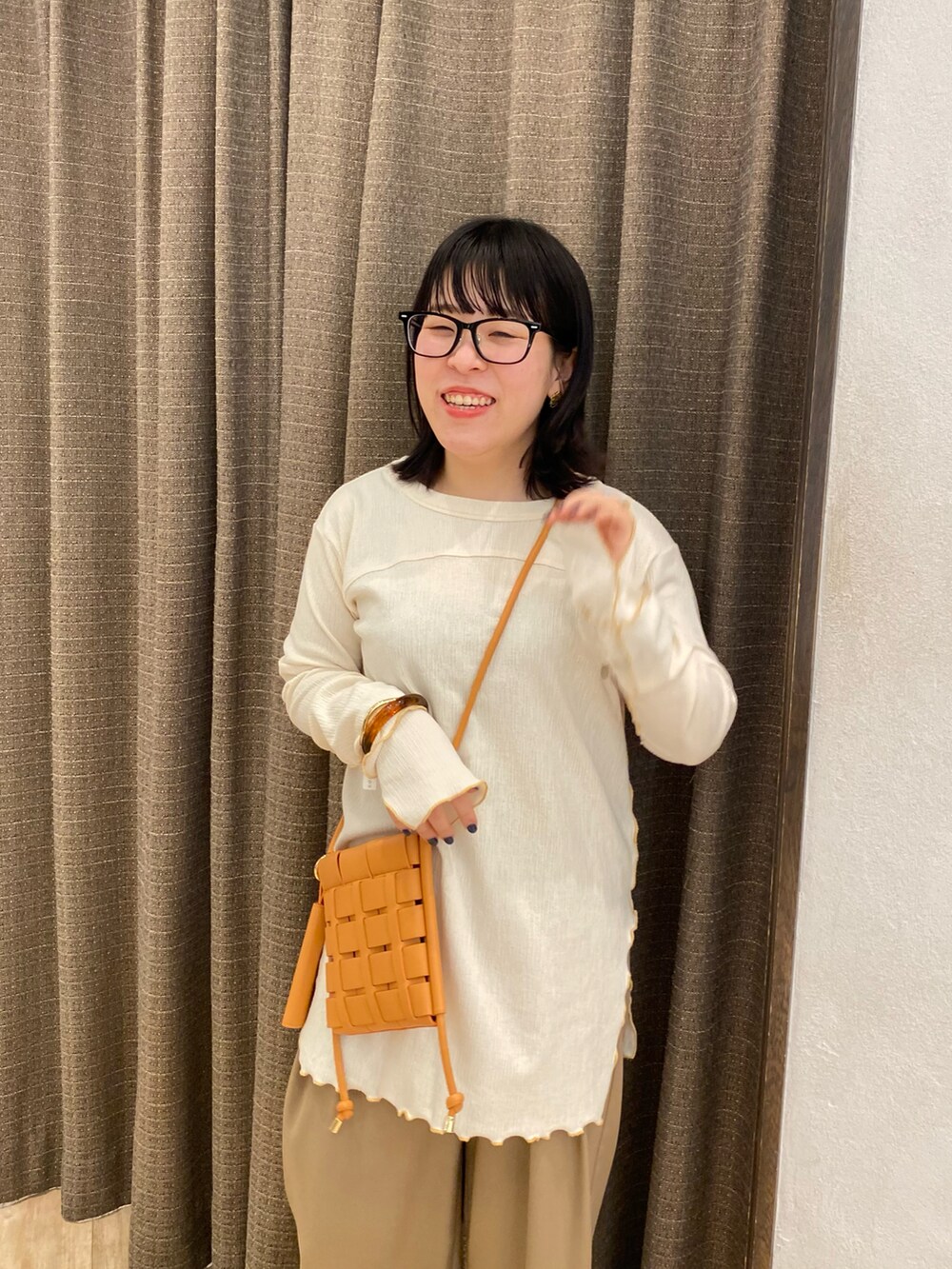 ブラック系のその他パンツ、ホワイト系のTシャツ/カットソー、オレンジ系のショルダーバッグを着用したレディースの春コーディネートの3枚目の写真