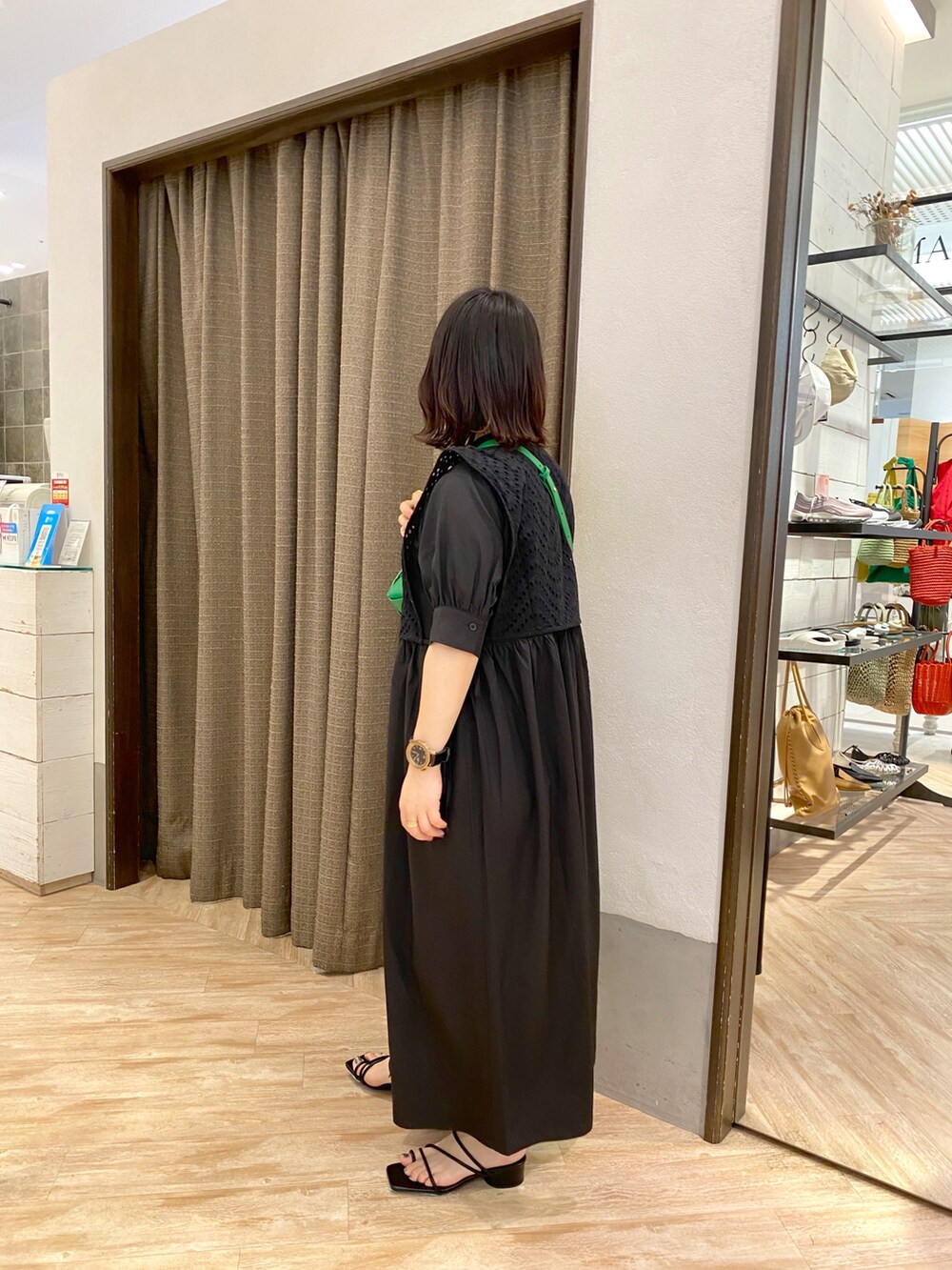 ブラック系のサンダル、ブラック系のワンピース、グリーン系のボディバッグ/ウエストポーチを着用したレディースの夏コーディネートの2枚目の写真