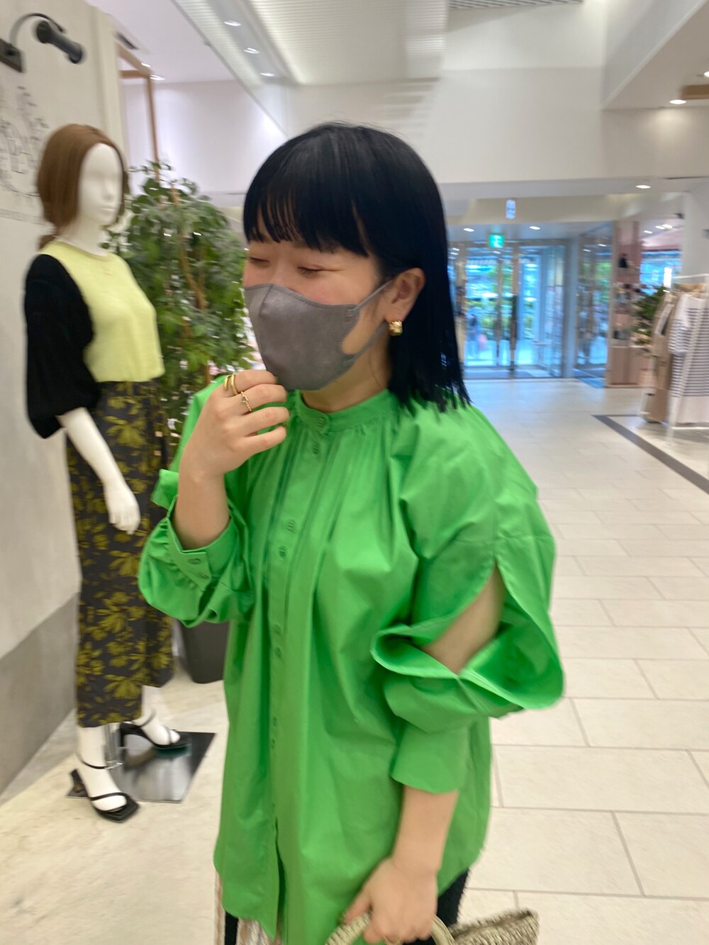 グリーン系のシャツ/ブラウス、グリーン系のトートバッグ、ブラック系のスカートを着用したレディースの春コーディネートの2枚目の写真