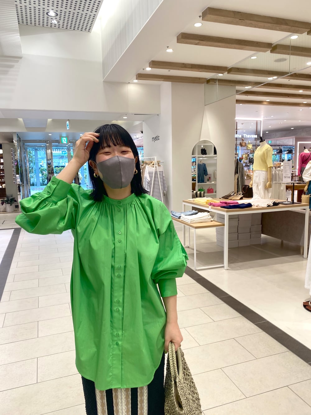 グリーン系のシャツ/ブラウス、グリーン系のトートバッグ、ブラック系のスカートを着用したレディースの春コーディネートの3枚目の写真