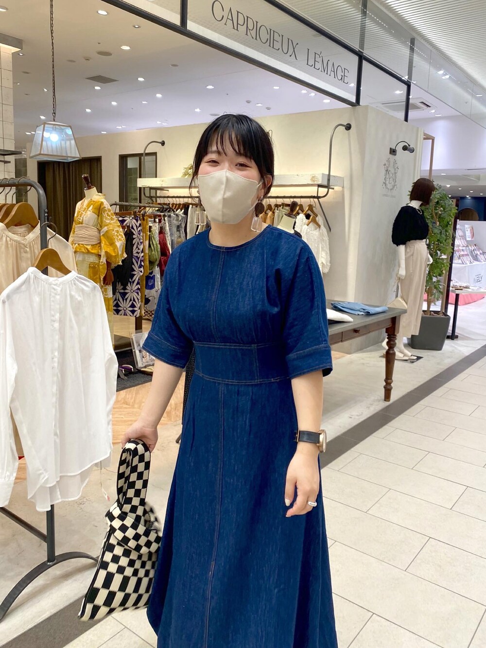 ブルー系のワンピース、ホワイト系のショルダーバッグ、ブラック系のサンダルを着用したレディースの夏コーディネートの2枚目の写真