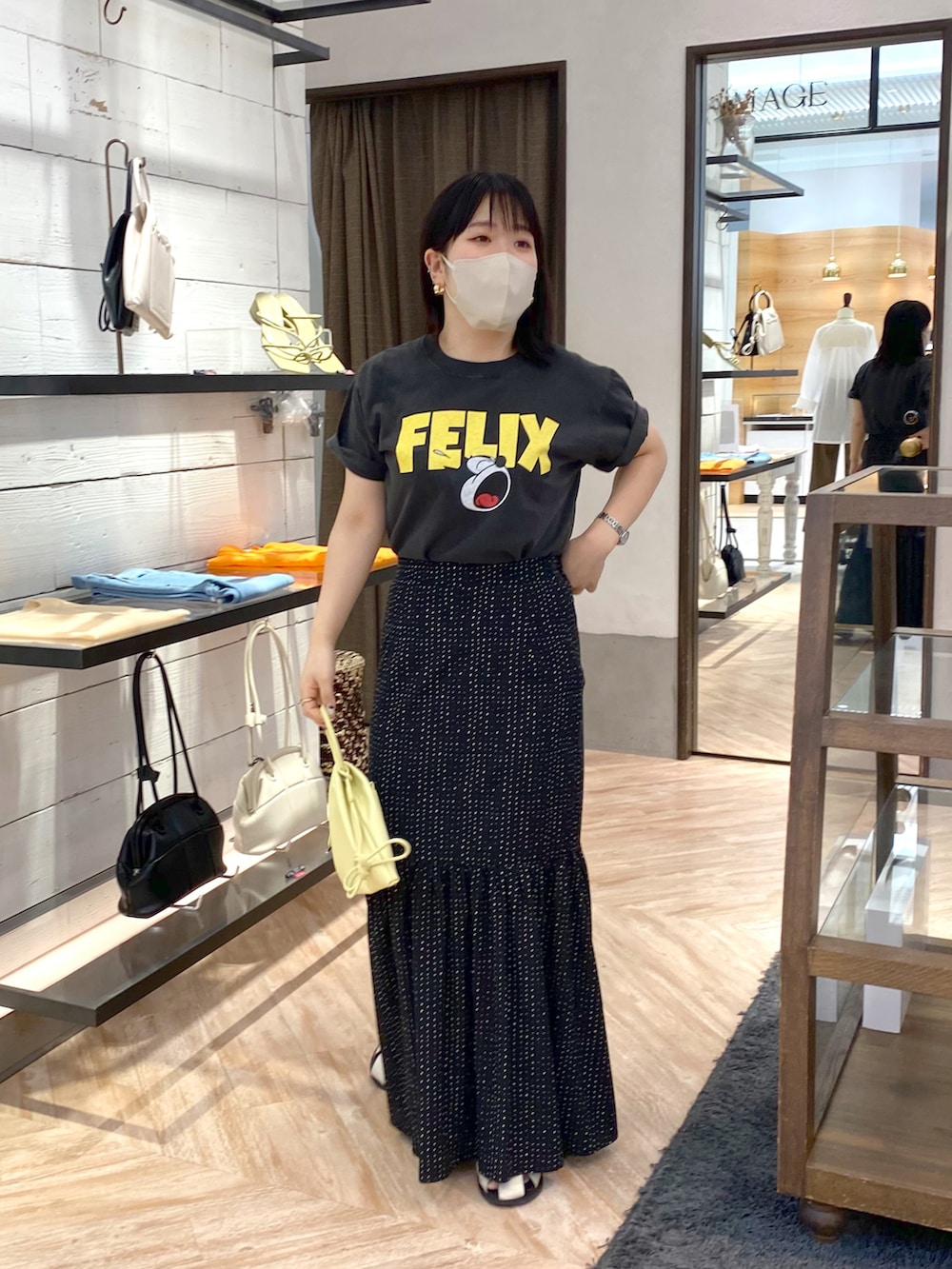 ブラック系のTシャツ/カットソー、ブラック系のスカート、ホワイト系のショルダーバッグを着用したレディースの夏コーディネートの2枚目の写真