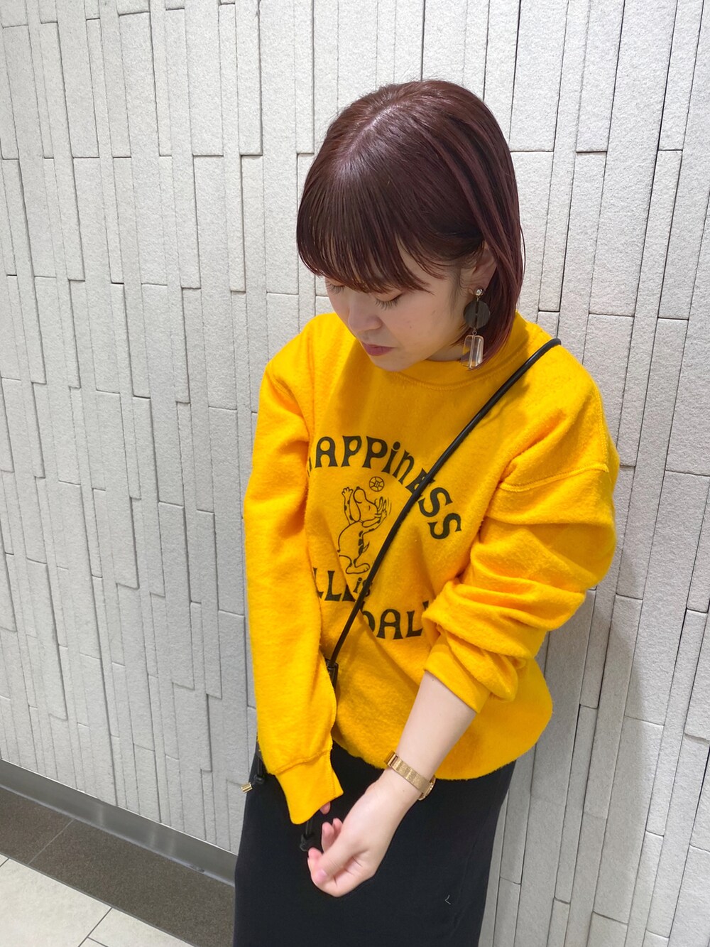 イエロー系のスウェット、ブラック系のワンピース、ブラック系のブーツを着用したレディースの冬コーディネートの2枚目の写真