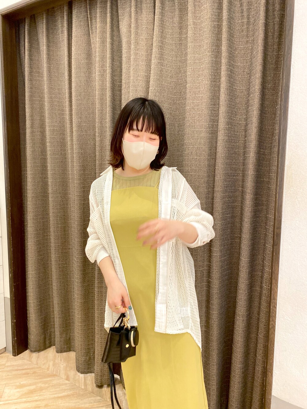 ホワイト系のシャツ/ブラウス、イエロー系のワンピース、シルバー系のパンプスを着用したレディースの夏コーディネートの2枚目の写真