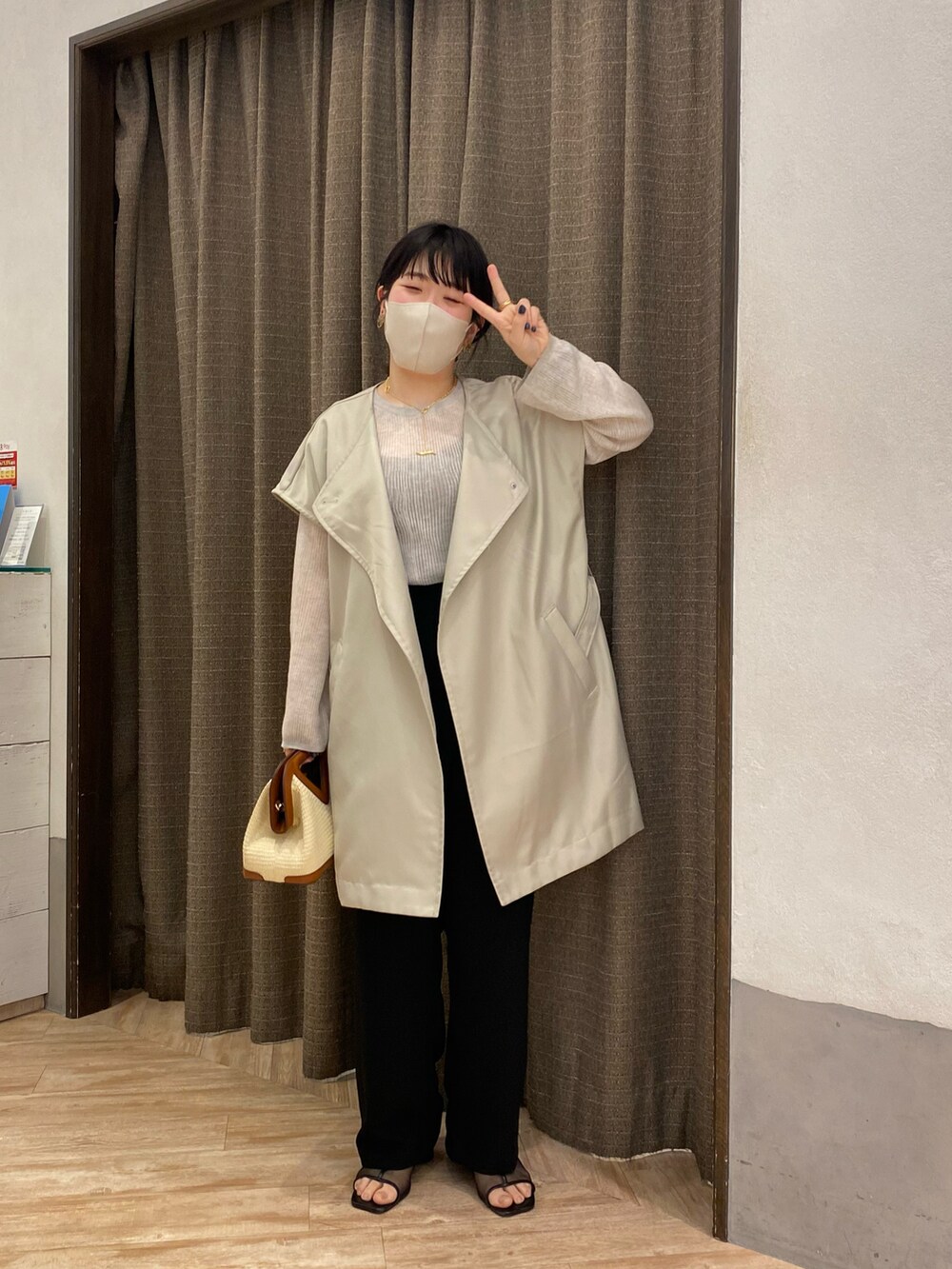 ブラック系のその他パンツ、ベージュ系のベスト、ブラウン系のショルダーバッグを着用したレディースの春コーディネートの3枚目の写真