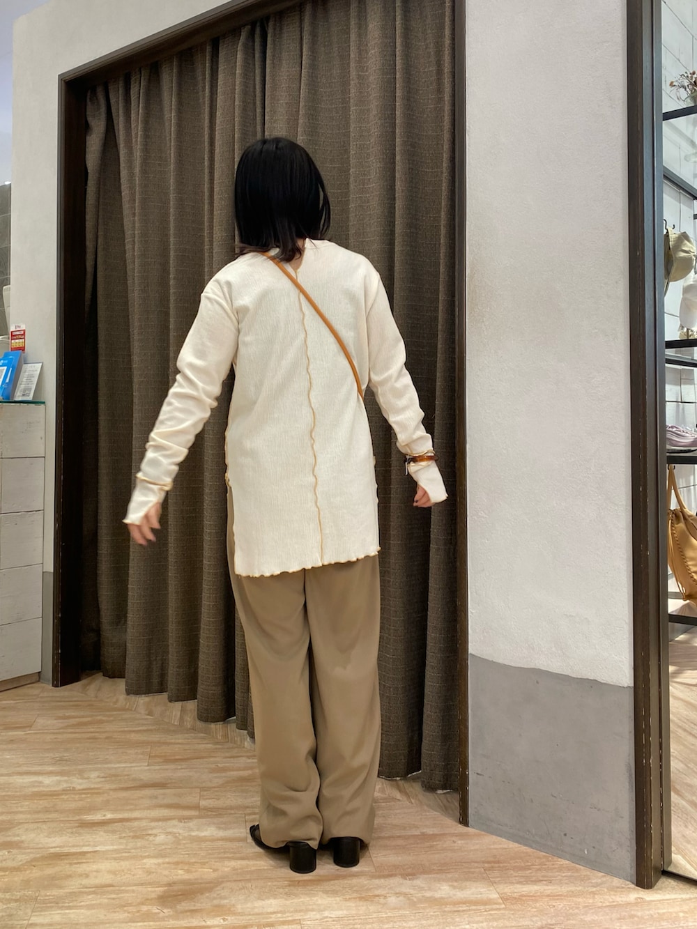 ブラック系のその他パンツ、ホワイト系のTシャツ/カットソー、オレンジ系のショルダーバッグを着用したレディースの春コーディネートの2枚目の写真