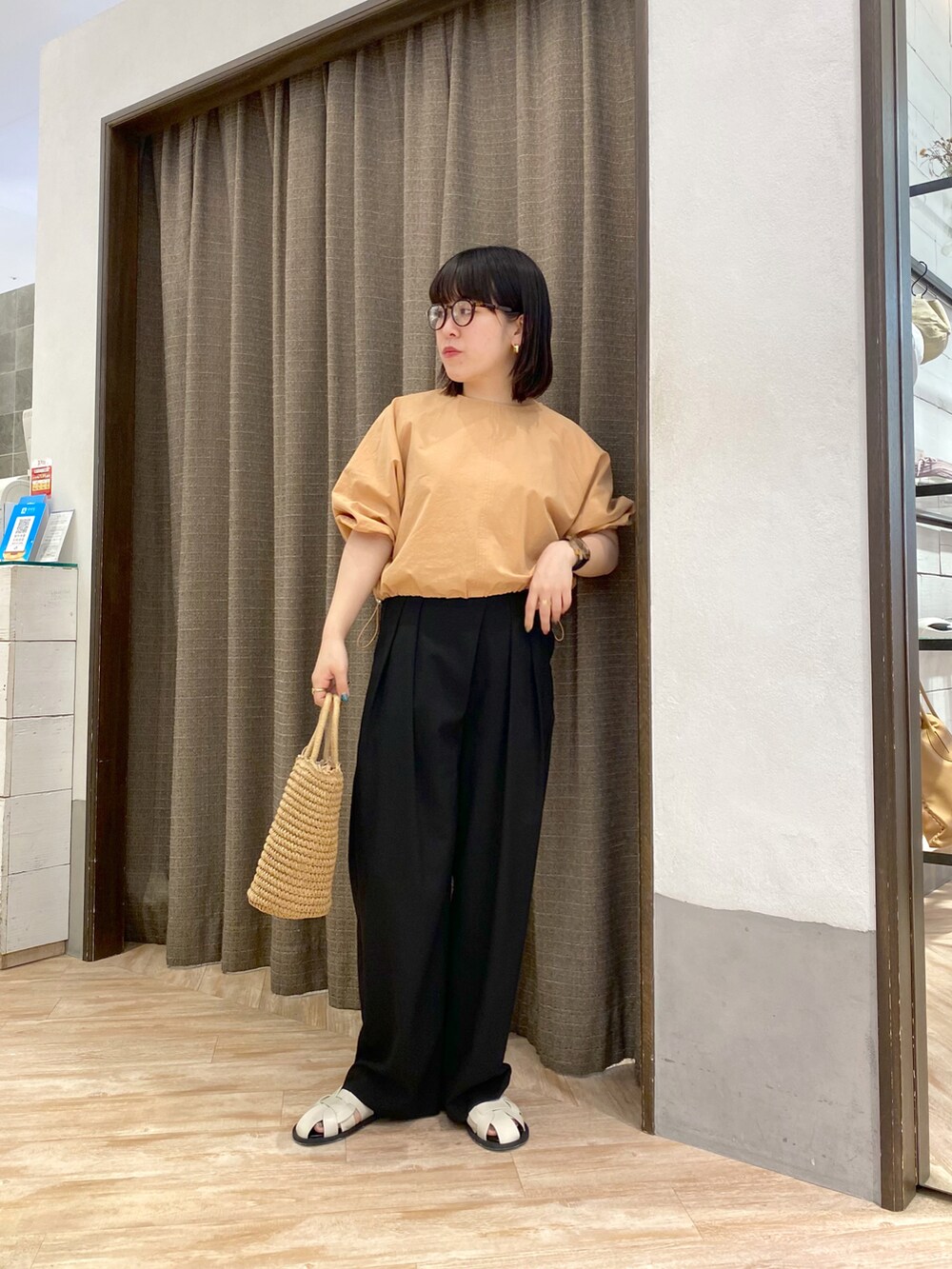 オレンジ系のシャツ/ブラウス、ブラック系のその他パンツ、ホワイト系のサンダルを着用したレディースの夏コーディネートの2枚目の写真