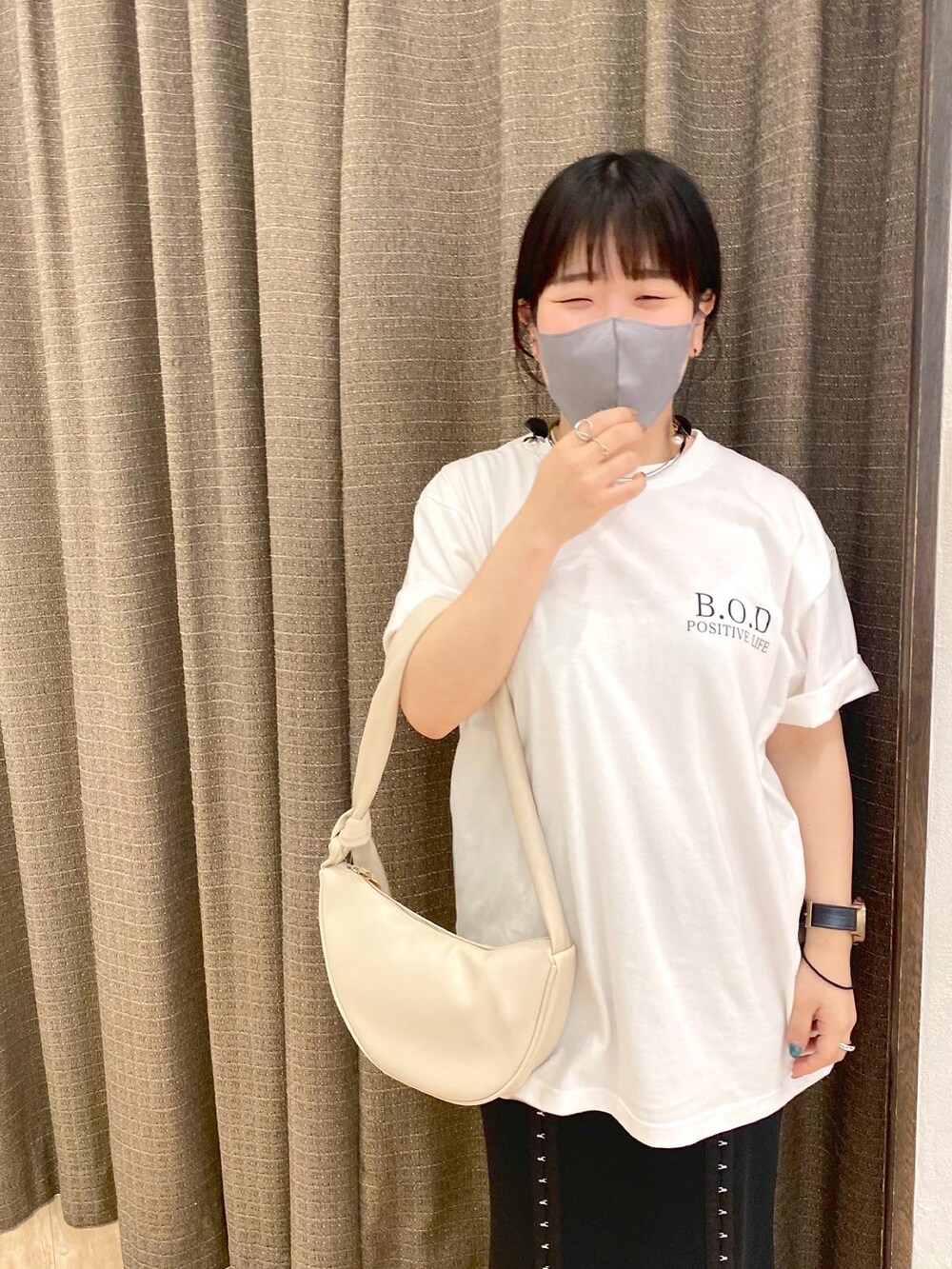 ホワイト系のショルダーバッグ、ホワイト系のTシャツ/カットソー、ブラック系のスカートを着用したレディースの夏コーディネートの2枚目の写真